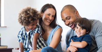 A happy family laughing on the sofa.