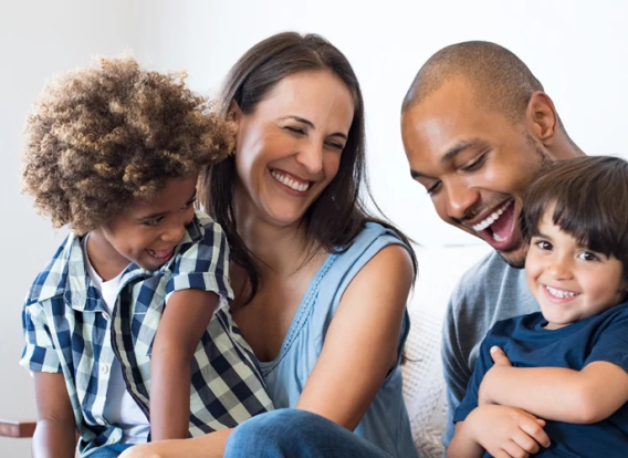 A happy family laughing on the sofa.