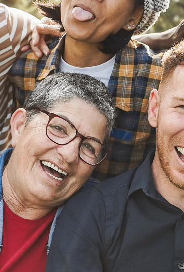 Group of multigenerational people smiling in front of camera - Multiracial friends od different ages having fun together - Main focus on caucasian senior faces